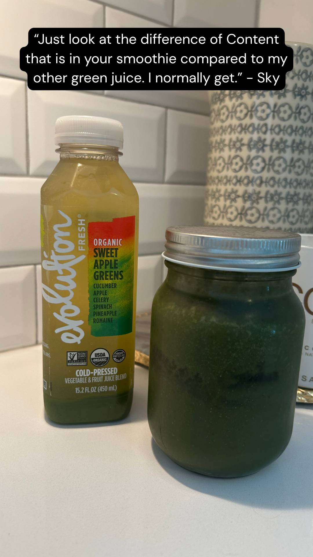 A bottled green juice labeled "Organic Sweet Apple Greens" sits next to a mason jar filled with a darker green smoothie on a kitchen counter.